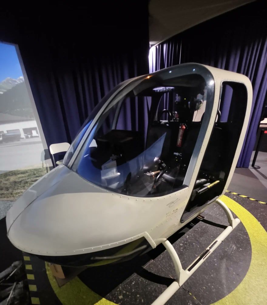 Bell 407 Simulator mit Cockpitkanzel im abgedunkelten Simulatorraum.